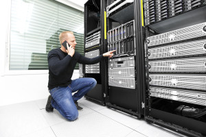 It engineer or technician monitors and solving problems with blade servers in data rack. Calling technical support about hardware problems in datacenter.